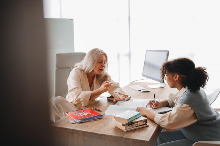An older female tutor reviewing progress reports with a younger female student.